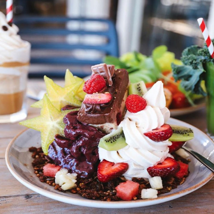 Plate with Cocowhip, fruit, acai and raw dessert